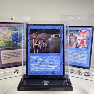May include: A blue Magic: The Gathering card with the text "Time Walk" and "Take an extra turn after this one." The card features an illustration of two skeletal figures walking towards a stone archway.