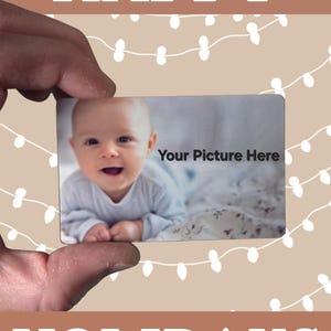 May include: A rectangular card featuring a photograph of a smiling baby and the text 'Your Picture Here'. The card is set against a tan background with white string light illustrations and the white text 'HAPPY HOLIDAYS' at the top and bottom.