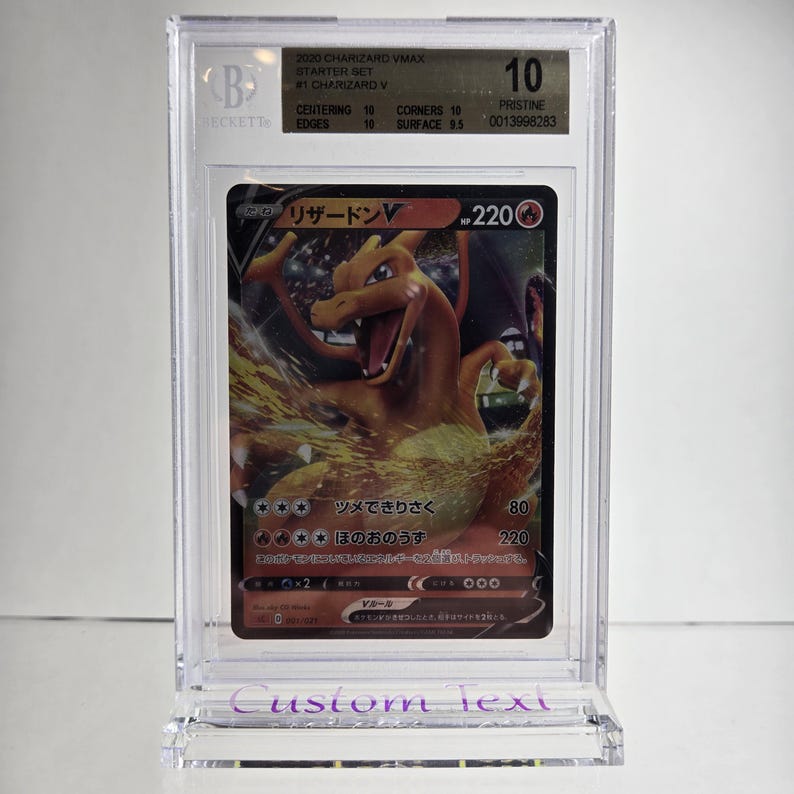 Puede incluir: Una tarjeta coleccionable Charizard VMAX calificada del Starter Set 2020, dentro de un soporte protector transparente. La tarjeta presenta una ilustraci&oacute;n de drag&oacute;n naranja llameante y texto japon&eacute;s. El soporte est&aacute; calificado con un 10 por Beckett.