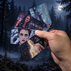 May include: Three rectangular plastic cards featuring holographic star patterns and imagery from the Twilight film series. One card shows a person with the text "HOW MUCH?!", another says "STOP SPENDING!", and the third displays a shirtless person.