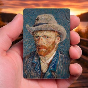 May include: A rectangular art print featuring a portrait of Vincent van Gogh in a hat and coat. The painting has a blue background with visible brushstrokes. The artist's face is detailed with a red beard and yellow skin tones.