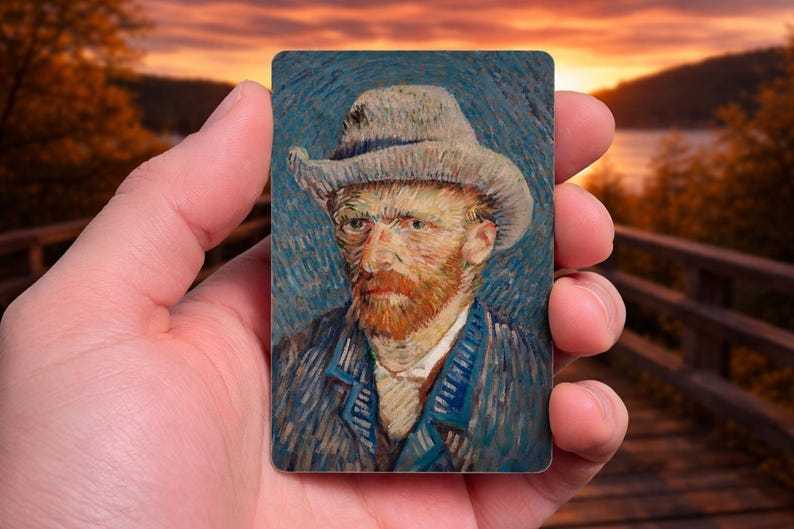 May include: A rectangular art print featuring a portrait of Vincent van Gogh in a hat and coat. The painting has a blue background with visible brushstrokes. The artist's face is detailed with a red beard and yellow skin tones.