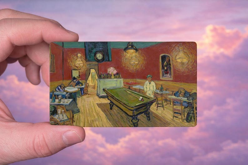 May include: A rectangular painting depicting Van Gogh's "The Night Cafe" with a green pool table, figures at tables, and a clock on the wall. The artwork is held against a backdrop of a pink and purple sky.