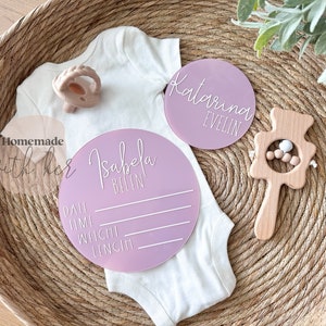 May include: Two pink acrylic baby announcement plaques. One plaque says "Isabela Belen" and has lines for date, time, weight, and length. The other plaque says "Katarina Evelin".