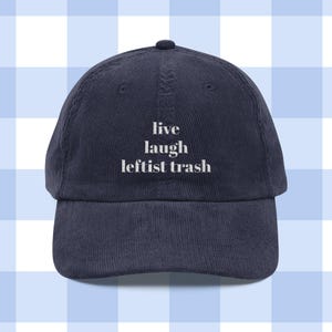 May include: Navy blue corduroy baseball cap with the words "live laugh leftist trash" in white, centered on the front. The cap has a curved brim and a small button on top.
