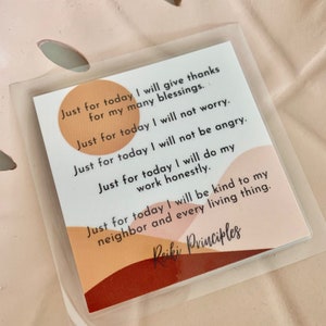 May include: A card with the text "Just for today I will give thanks for my many blessings." The card is in a clear plastic sleeve, with a pink background. The words "Reiki Principles" are at the bottom.