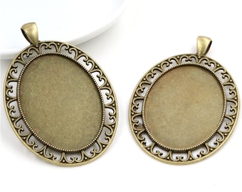 May include: Two antique gold oval pendant trays with a decorative heart-shaped border. The trays are blank and ready for crafting.