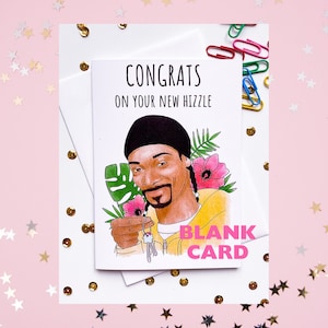 May include: A greeting card with a cartoon illustration of a person with a black beanie and a yellow shirt holding keys. The card says "Congrats on your new hizzle" and "Blank Card".