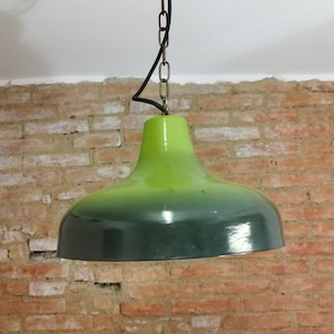 Könnte beinhalten: Eine grüne und dunkelgrüne Glas-Pendelleuchte, die an einer Kette hängt.