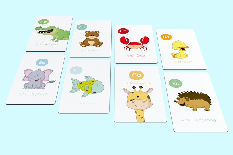 May include: A set of eight alphabet flash cards featuring colorful illustrations of animals. Each card has a letter, the animal's name, and the phrase "is for" written on it. The animals include an alligator, bear, crab, duck, elephant, fish, giraffe, and hedgehog.