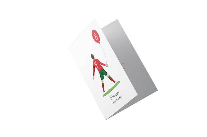 May include: A white card with a red and green illustration of a soccer player holding a red balloon with the number 8 on it. The text "Harrison Happy Birthday!" is printed on the card.