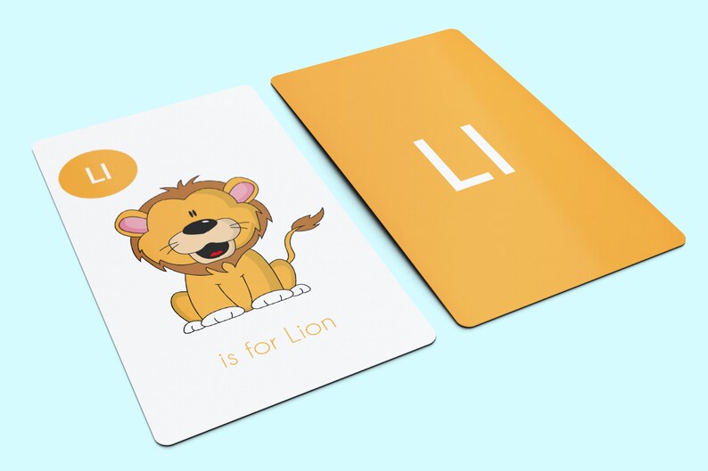 May include: A white card with a yellow circle containing the letter "L" and the word "Lion" written below. A cartoon lion is pictured on the card. The back of the card is yellow with the letter "L" in white.
