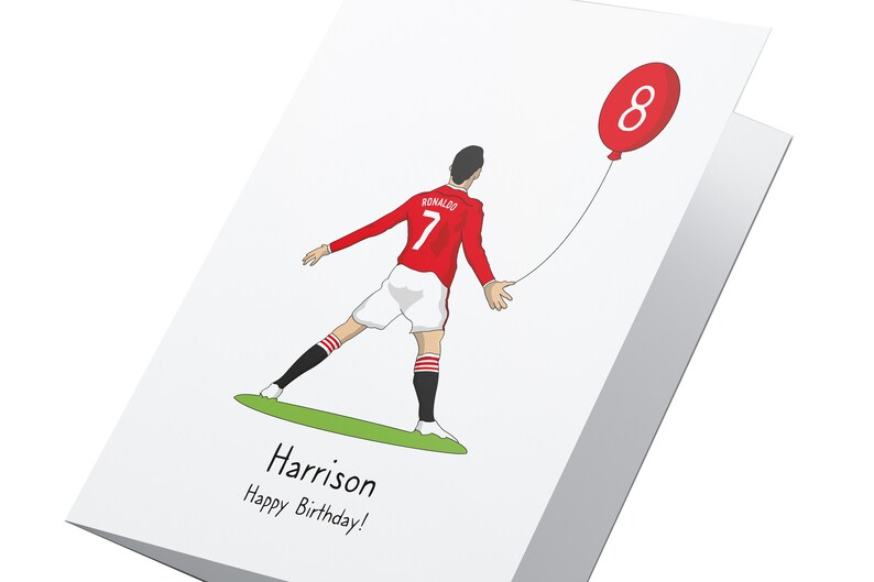 Puede incluir: Una tarjeta de cumplea&ntilde;os con una ilustraci&oacute;n de dibujos animados de un jugador de f&uacute;tbol que lleva una camiseta roja y blanca con el n&uacute;mero 7 y el nombre "RONALDO" en la espalda. El jugador sostiene un globo rojo con el n&uacute;mero 8. La tarjeta dice "Harrison &iexcl;Feliz cumplea&ntilde;os!" en la parte inferior.
