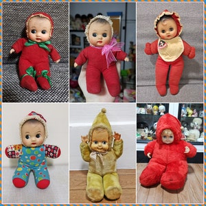 Puede incluir: Una colección de seis muñecas de peluche vintage. Las muñecas están todas vestidas con diferentes atuendos, incluyendo un vestido rojo con cuello blanco, un vestido amarillo con un lazo rojo y un vestido azul con lunares blancos. Las muñecas sonríen todas y tienen ojos grandes.