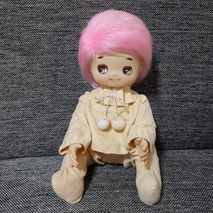 Boneca de pelúcia vintage com rosto de borracha e olhos grandes, cabelo rosa bebê