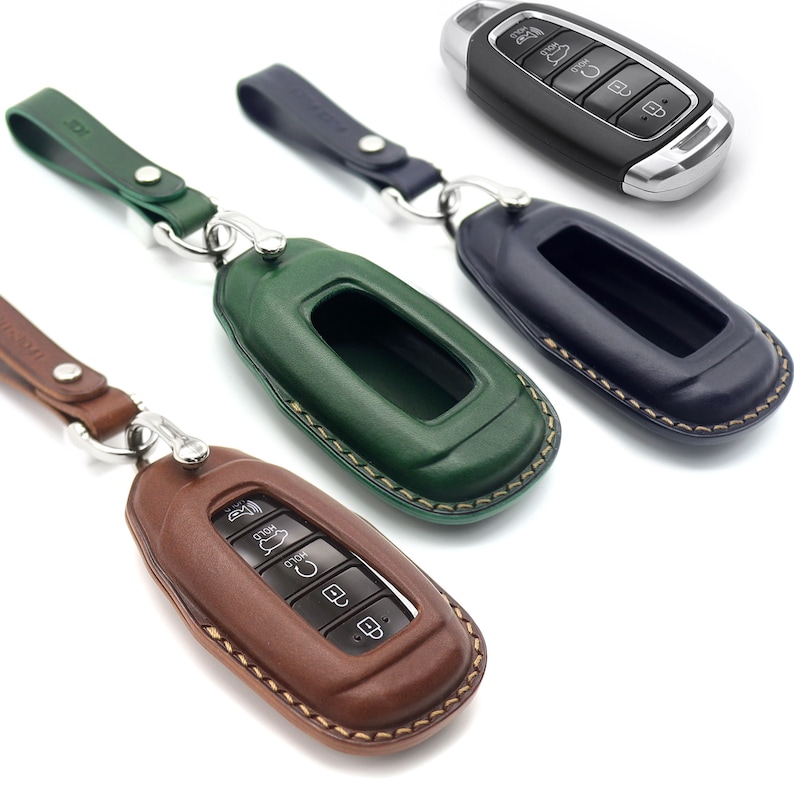 Puede incluir: Tres llaveros de cuero en verde, marr&oacute;n y azul con una cadena. Los llaveros est&aacute;n dise&ntilde;ados para adaptarse a una llave de coche con un panel de botones. Los llaveros tienen un borde cosido.