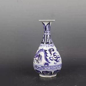 May include: A white and blue ceramic vase with a flared top and a bulbous body. The vase features a blue dragon design and Chinese characters. The vase is approximately 10 inches tall.