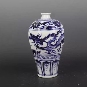 May include: A white porcelain vase with a blue and white dragon design. The vase has a round body and a narrow neck. The dragon is depicted in a dynamic pose, with its wings spread and its tail curled.