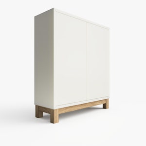 May include: A white cabinet with two doors and wooden legs. The cabinet has a simple design and is made of a smooth, white material.