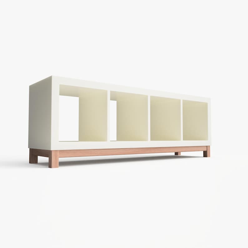 May include: White bookshelf with four open shelves and a wooden base. The bookshelf is made of wood and has a modern design.