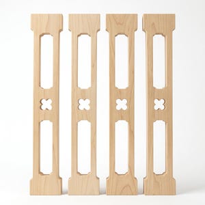 May include: Four vertical light-colored wooden balusters arranged in a row. Each baluster features a rectangular cutout at the top and bottom, separated by a central four-lobed clover-shaped cutout. The wood grain is visible throughout the pieces.