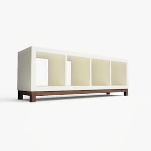 May include: White bookshelf with four open shelves and a brown wood base. The bookshelf is on a white background.