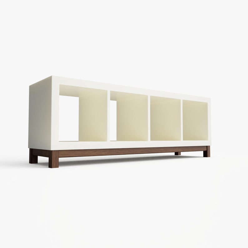 May include: White bookshelf with four open shelves and a brown wood base. The bookshelf is on a white background.