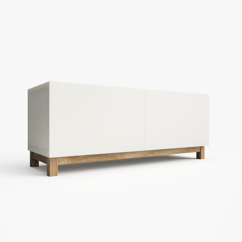 May include: A white media console with two doors and a wooden base. The console is made of wood and has a modern design.