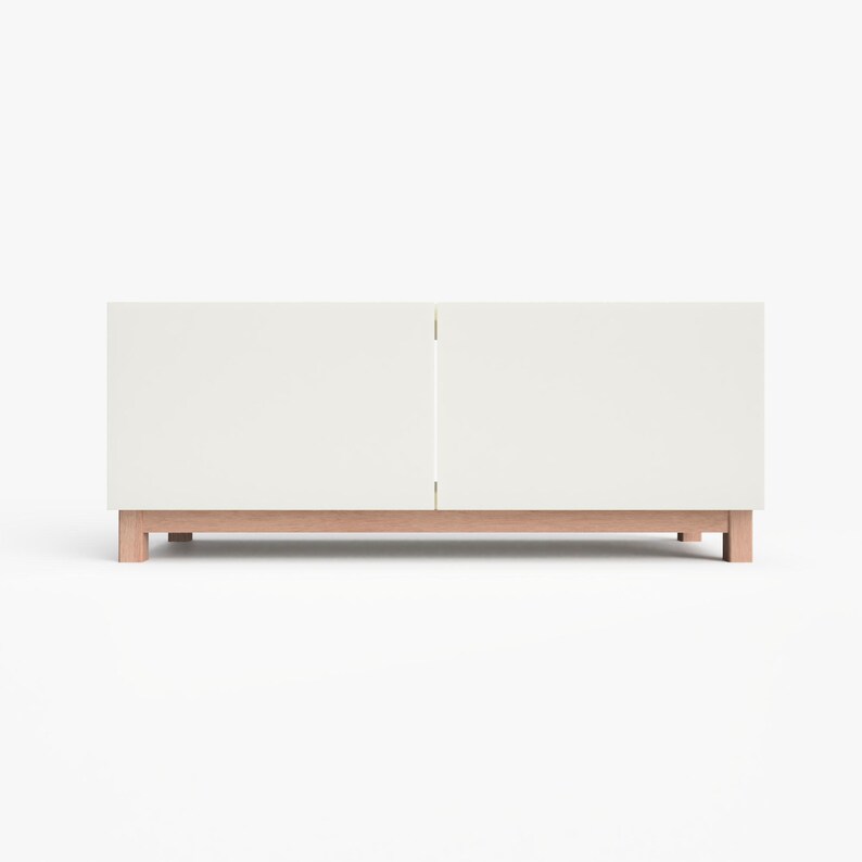 May include: White media console with two doors and a wood base. The console has a simple, modern design.