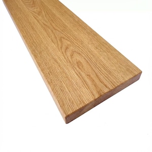 Può includere: Una tavola di legno rettangolare, marrone chiaro, con venature visibili. La tavola ha una superficie liscia e rifinita, probabilmente per la costruzione o la lavorazione del legno. I bordi sono tagliati in modo pulito e l'aspetto generale è naturale e rustico.