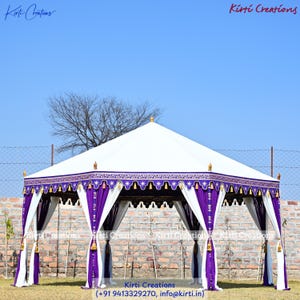 May include: A large hexagonal outdoor tent featuring a white canopy roof and deep purple valances with white star-shaped embroidery and gold tassels. The structure includes white and purple fabric drapes tied at each of the six support poles.
