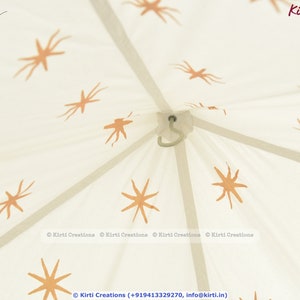 May include: White canvas tent with a star pattern printed on it. The tent has a hook at the top and is made of cotton.