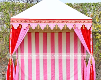 May include: A white canopy tent with pink and red striped fabric walls and gold tassels. The tent is decorated with a red and gold trim and has a white roof.