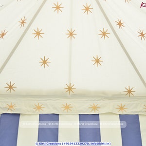 May include: A white canopy tent with a blue and white striped base. The canopy is decorated with gold stars.