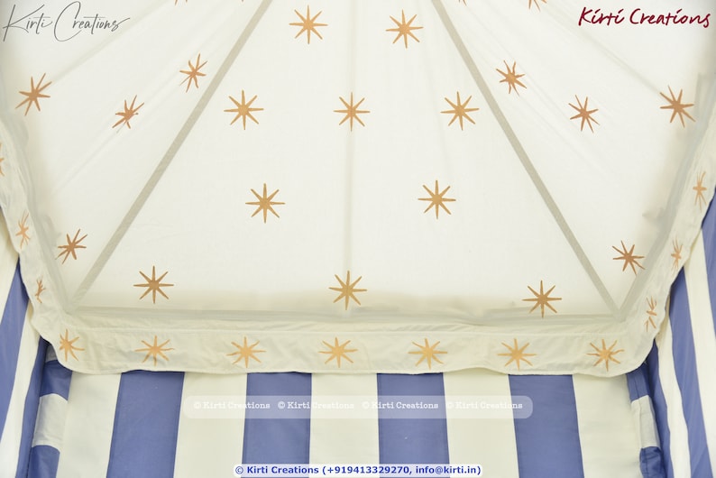 May include: A white canopy tent with a blue and white striped base. The canopy is decorated with gold stars.