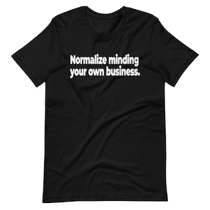 Puede incluir: Camiseta negra con texto blanco que dice "Normalizar ocuparse de sus propios asuntos."