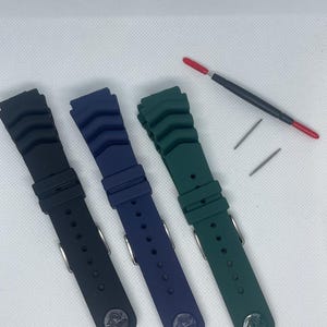 Peut inclure: Trois bracelets de montre en noir, bleu et vert. Les bracelets sont en caoutchouc et ont un design textur&eacute;. Chaque bracelet a une boucle en m&eacute;tal.