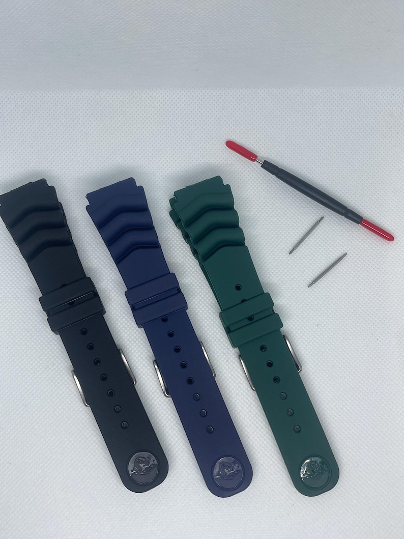 Peut inclure: Trois bracelets de montre en noir, bleu et vert. Les bracelets sont en caoutchouc textur&eacute; et ont une boucle argent&eacute;e.