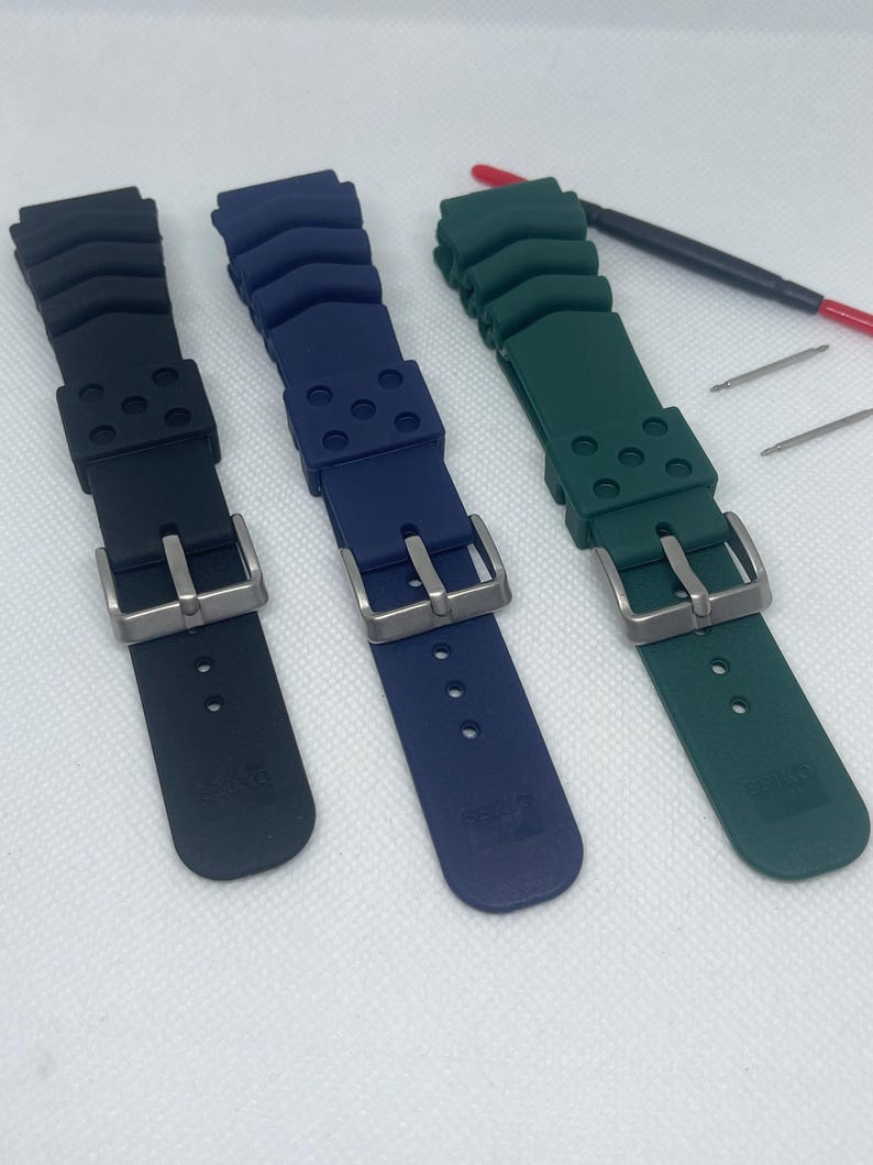Peut inclure: Trois bracelets de montre en noir, bleu et vert. Les bracelets sont en caoutchouc textur&eacute; et ont une boucle argent&eacute;e.
