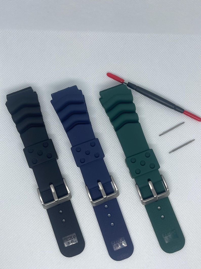 Peut inclure: Trois bracelets de montre en noir, bleu et vert. Chaque bracelet est dot&eacute; d'une boucle argent&eacute;e et du texte "SEIKO JAPAN" imprim&eacute; au dos.