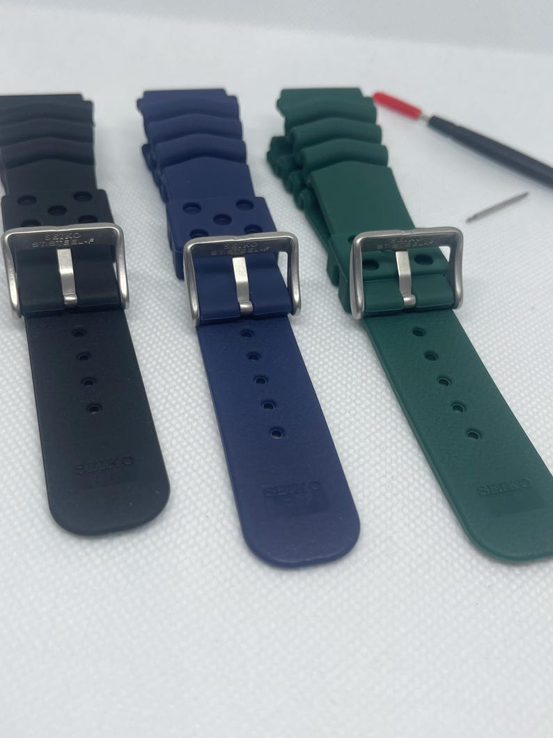 Peut inclure: Trois bracelets de montre en noir, bleu et vert. Chaque bracelet est fait d'un mat&eacute;riau en caoutchouc textur&eacute; et poss&egrave;de une boucle en acier inoxydable. Les bracelets sont tous de la m&ecirc;me taille et du m&ecirc;me style.