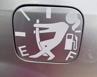 Puede incluir: Un adhesivo de vinilo blanco sobre una tapa de combustible plateada, con un gráfico estilizado de una persona tirando de la aguja de un indicador de combustible hacia la F. El diseño incluye las letras E y F, un icono de surtidor y marcas.