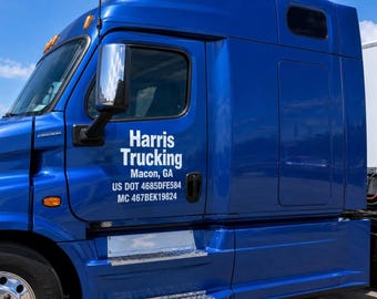 Puede incluir: Una cabina de camión semirremolque de color azul brillante con texto blanco en la puerta que dice Harris Trucking, Macon, GA, US DOT 4685DFE584 y MC 467BEK19824. El vehículo incluye un espejo lateral cromado, luces de posición naranjas y un estribo metálico.