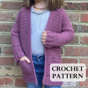 May include: A crochet cardigan pattern for a child's sweater. The cardigan is a light purple color and has pockets. The pattern is available for download.