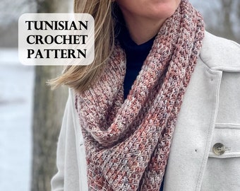 May include: A woman wearing a white coat and a pink, brown, and gray Tunisian crochet scarf. The scarf is a simple, textured design. The text "TUNISIAN CROCHET PATTERN" is visible in the image.