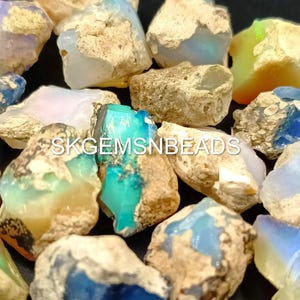 Puede incluir: Una colecci&oacute;n de piedras de &oacute;palo natural en bruto en varios tonos de azul, verde, blanco y marr&oacute;n. Las piedras tienen una forma irregular y una superficie rugosa y texturizada.