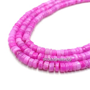 May include: Strands of pink gemstone beads. The beads are small, flat, and disc-shaped, with a consistent size and shape. The color varies from light to deep pink. The beads are strung together, forming a necklace or bracelet.