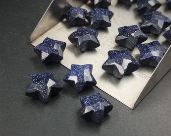 Può includere: Una collezione di pietre blu a forma di stella con una finitura scintillante. Le pietre sono disposte su un vassoio di metallo con il testo "Em 26 81 Colors" e "all.com".