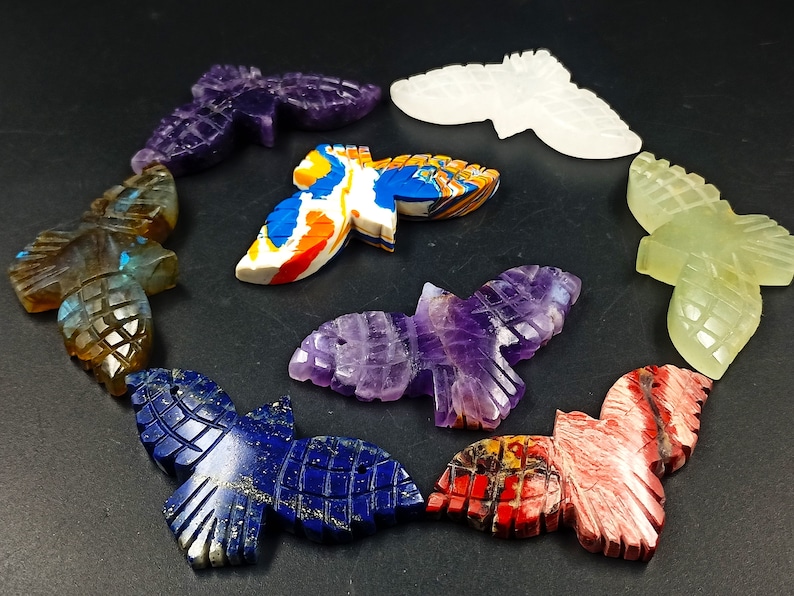 May include: A collection of nine carved gemstone butterfly pendants in various colors, including amethyst, labradorite, lapis lazuli, and green aventurine.