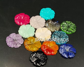May include: A collection of carved gemstone flower shapes in various colors, including pink, turquoise, white, gray, green, purple, yellow, orange, black, and blue. The gemstones are arranged on a dark surface.